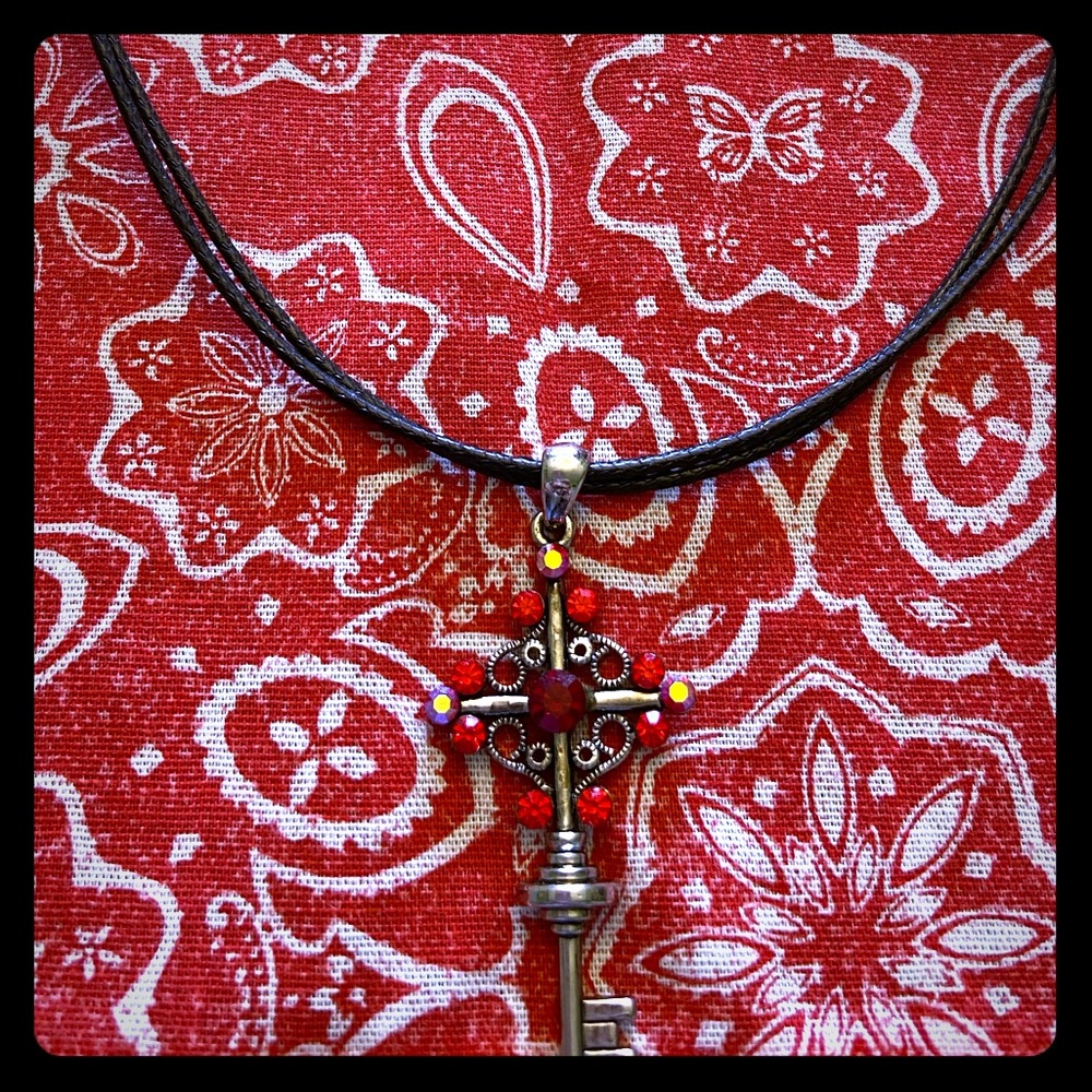 Jeweled cross/key pendant on a black rope necklace